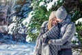 Couple in love covered with blanket hugs in winter forest Royalty Free Stock Photo