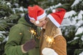 Couple in love on date celebrate valentine`s day, christmas, new year. guy girl hugging, lighting sparklers, kissing, under fir t Royalty Free Stock Photo