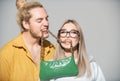 Couple in love on date in formal fashion look. Ladies handbag. Beautiful woman and man holds fashion handbag in mouth. Royalty Free Stock Photo