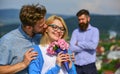 Couple in love dating while jealous bearded man watching wife cheating him with lover. Lovers hugs outdoor flirt romance Royalty Free Stock Photo