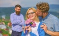 Couple in love dating while jealous bearded man watching wife cheating him with lover. Lovers hugs outdoor flirt romance Royalty Free Stock Photo
