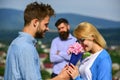 Couple in love dating while jealous husband fixedly watching on background. Couple romantic date lover present bouquet Royalty Free Stock Photo