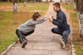A couple are doing sports in the park in the fall. Stretch muscles holding hands. Royalty Free Stock Photo