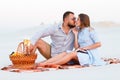 Couple in love drinking wine during romantic dinner on the beach, young couple kissing and holding glasses in hands Royalty Free Stock Photo