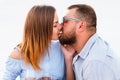 Couple in love drinking wine during romantic dinner on the beach, young couple kissing and holding glasses in hands Royalty Free Stock Photo