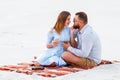 Couple in love drinking wine during romantic dinner on the beach, young couple kissing and holding glasses in hands Royalty Free Stock Photo