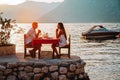 Couple in love drinking wine on romantic dinner at sunset on the beach. Royalty Free Stock Photo