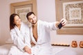 Couple in love enjoying wellness weekend and taking selfies in spa Royalty Free Stock Photo