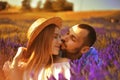 A couple in love in a field of lavender at sunset in good weather. Beautiful woman in a dress and straw panama with a man on the Royalty Free Stock Photo