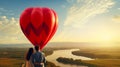 A couple in love is flying on a large, red, heart-shaped balloon high in the clouds above the mountains, at sunset