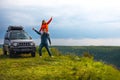 A couple in love fooling around, having fun, good mood on a trip, vacation. old SUV car, trip at warm summer day. Man and woman Royalty Free Stock Photo