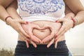 Pregnant couple making a heart with their hands on their belly Royalty Free Stock Photo