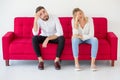 couple in love girlfriend and boyfriend having quarrel on red sofa at home, indoors . Upset Royalty Free Stock Photo