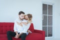 Couple in love girlfriend hugging her boyfriend on red sofa at home,Loving everything together,Happy and smiling Royalty Free Stock Photo