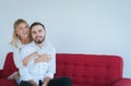 Couple in love girlfriend hugging her boyfriend on red sofa at home,Loving everything together,Happy and smiling Royalty Free Stock Photo