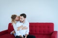 Couple in love girlfriend hugging her boyfriend on red sofa at home,Loving everything together,Happy and smiling Royalty Free Stock Photo