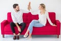 couple in love giving high five on the red sofa  at home, on white background. indoors Royalty Free Stock Photo