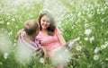 Couple in love guy and girl in a field of white daisies and green grass Royalty Free Stock Photo