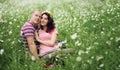 Couple in love guy and girl in a field of white daisies and green grass Royalty Free Stock Photo