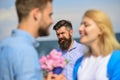 Couple in love happy dating, jealous bearded man watching wife cheating him with lover. Lovers meeting outdoor flirt