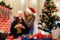 Couple in love in hats at Christmas gives each other gifts. The