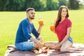 Couple in love have fun in the park and drink smoothies and eating fruit at a picnic Royalty Free Stock Photo