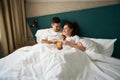 Couple in love is having breakfast in bed in hotel room Royalty Free Stock Photo