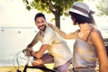 Couple in love having fun by bike on holiday to the lake