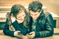 Couple in love having fun with modern phones Royalty Free Stock Photo