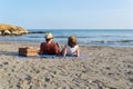 Couple in love having a picnic on a mediterranean beach at sunset