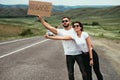 A couple in love hitchhiking. A young couple votes on the road. Travel on your own. Man and woman are hitchhiking. Royalty Free Stock Photo