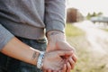 The couple in love holding hand in hand. Paired tattoo initials on the arms