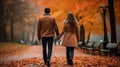 Couple in love holding hands on a walk in the park in autumn