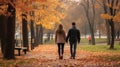Couple in love holding hands on a walk in the park in autumn
