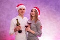 Couple in love holding wine bottle and glasses celebrating St. Valentine`s Day in studio Royalty Free Stock Photo