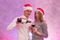 Couple in love holding wine bottle and glasses celebrating St. Valentine`s Day in studio Royalty Free Stock Photo