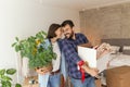 Couple in love hugging and carrying boxes while moving in new home Royalty Free Stock Photo