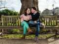 Couple in Love Hugging and Dating Sitting on a Bench in a Park Royalty Free Stock Photo