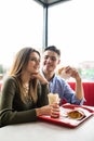 Couple in love hugging having fun, laughing and smiling together. Handsome boyfriend joke of her girlfriend and feed her, french f Royalty Free Stock Photo