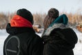 Couple in love hugging on romantic walk in park on winter day, back view. Rear view of young man and woman spending time together Royalty Free Stock Photo