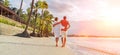 Couple in love hugging while walking on a sandy exotic beach. They have an evening walk by Trou-aux-Biches seashore on Mauritius Royalty Free Stock Photo