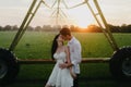 Couple in love kisses on lawn under water drops at sunset Royalty Free Stock Photo