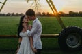 Couple in love kisses on lawn under water drops at sunset Royalty Free Stock Photo