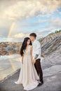 Couple in love kissing and hugging on the background of the rainbow and mountains. A man and a woman love each other. Fabulous Royalty Free Stock Photo