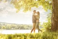 Couple in love on the lake, beneath the trees, kissing Royalty Free Stock Photo