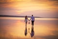 Couple in love at lake orange sunset, wailking in water