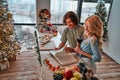 Couple in love looking for a recipe in a cookbook preparing food in the kitchen for New Year and Christmas. High angle view