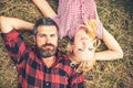 Couple in love lying on grass in forest or park. Romantic date in nature, love and relationship concept. Bearded man Royalty Free Stock Photo