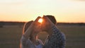 A couple in love makes a heart shape from their hands and kisses. Royalty Free Stock Photo