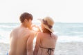 Couple in love making a heart - shape with hands on tropical on the sunset beach in holiday. Honeymoon relax together on summer t